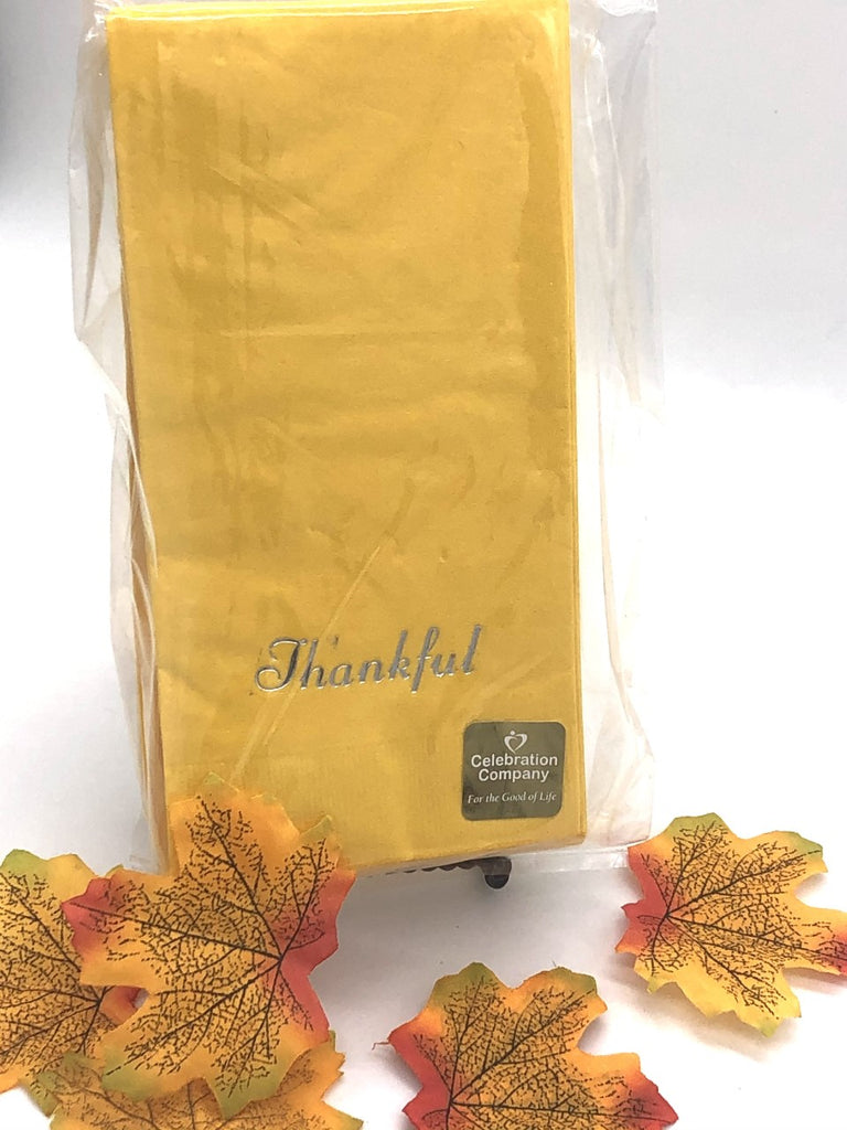 Yellow dinner napkin with gold Thankful slogan