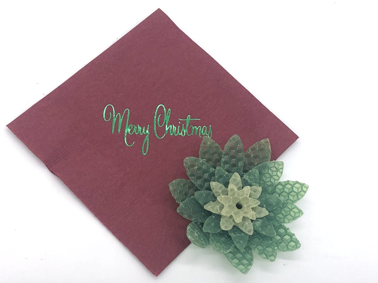 Red cocktail napkin with green Merry Christmas slogan