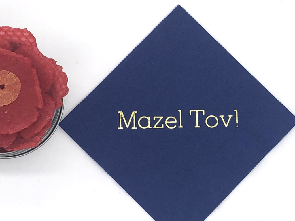Blue cocktail napkin with gold Mazel Tov! slogan