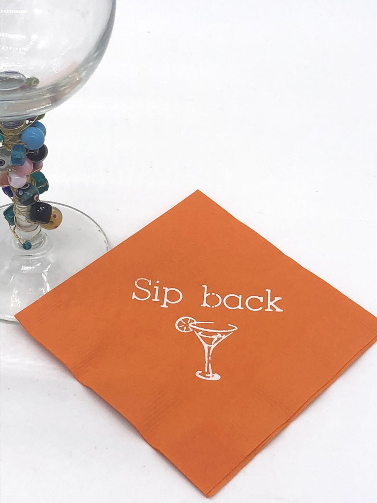 Burnt orange cocktail napkins with white sip back slogan and martini glass