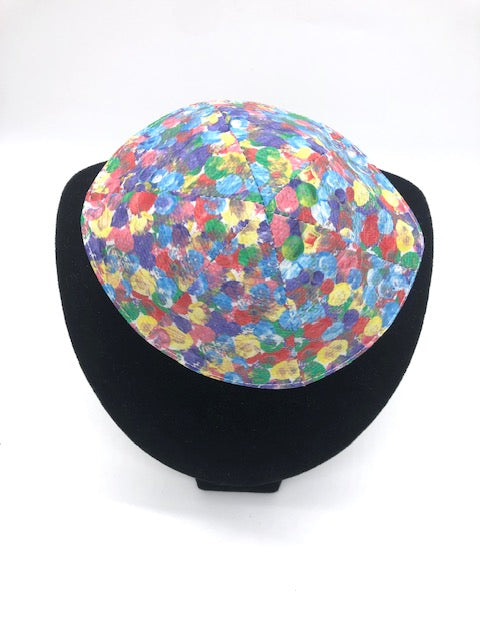 Kippah with multi colored dots on a velvet stand